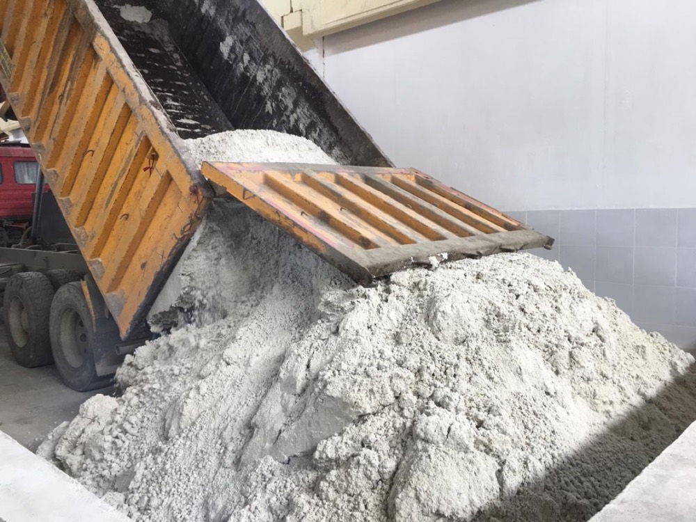 Oily perlite filter cake being delivered